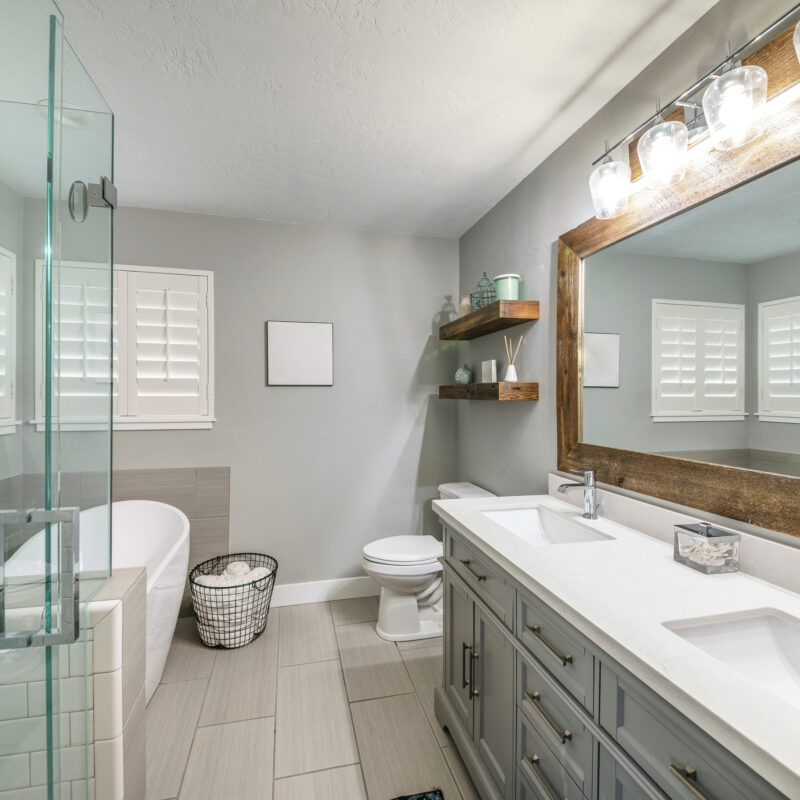 Modern bathroom with twin sinks, tub, and glass shower