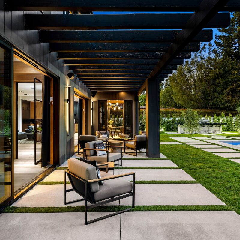 Modern outdoor patio with stylish furniture and lighting